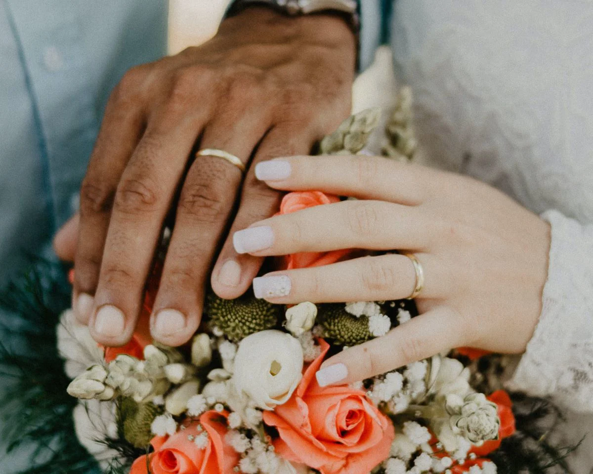 Hands On Top Of A Bouquet Of Flowers